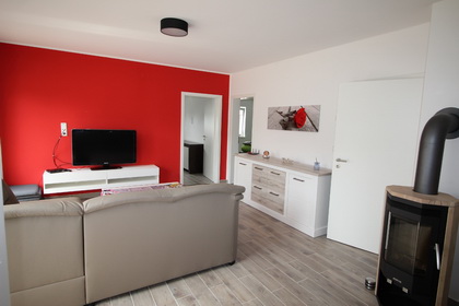 Das Wohnzimmer - Mit modernen Möbeln und großem Fernseher in der Ferienwohnung im Obergeschoss